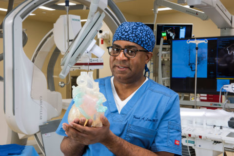 Dr Laws holding a heart model